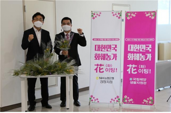 ▲꽃나눔 행사를 벌이는 박정인 국립해양생물자원관 경영전시본부장(사진 왼쪽)