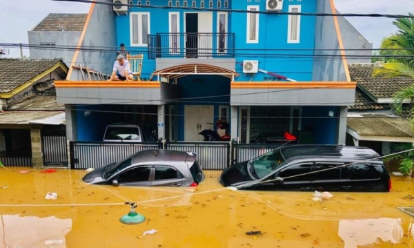 ▲인도네시아 자카르타에 위치한 주택 2층에서 집주인이 물에 잠긴 자동차들을 바라보고 있다.(사진제공 그린피스)