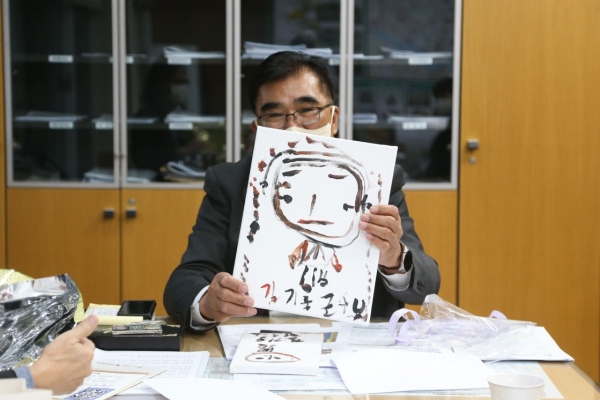 ▲발달장애인들로부터 도자기편에 그린 초상화를 선물받은 김기웅 군수